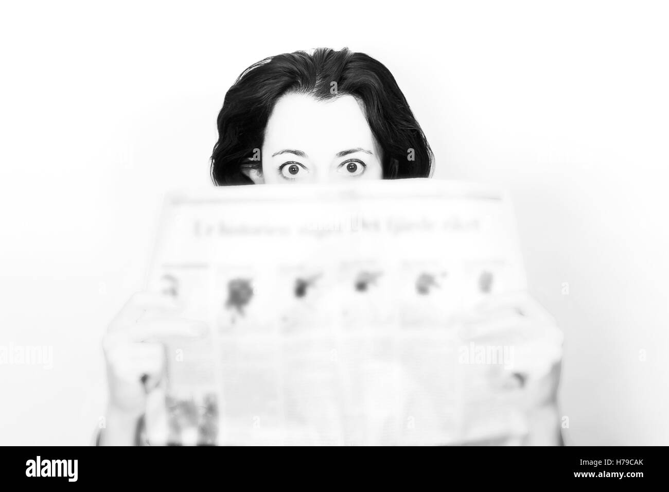 Schönheit Brünette Frau mit Zeitung unter Schock in schwarz / weiß Stockfoto