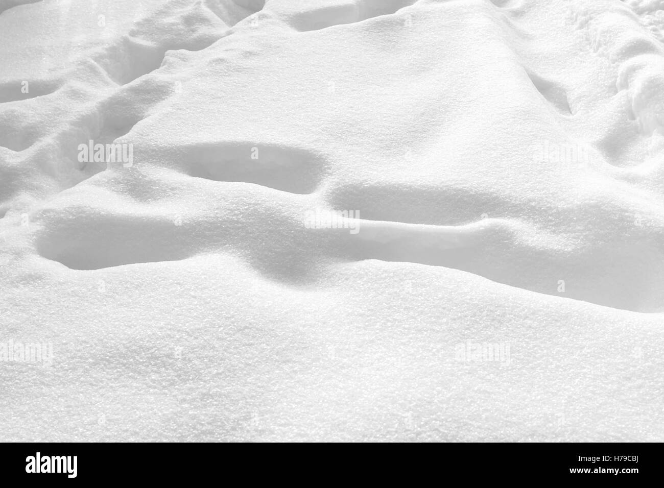 Zarte Fußspuren im Schnee am sonnigen Wintertag Stockfoto