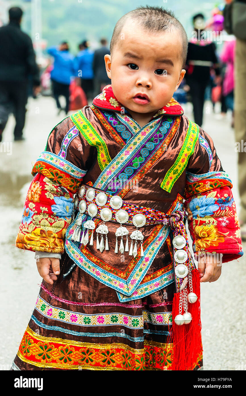 Ein Kind, gekleidet in traditionellen Miao-Kostüm für die Schwester Essen Festival Stockfoto