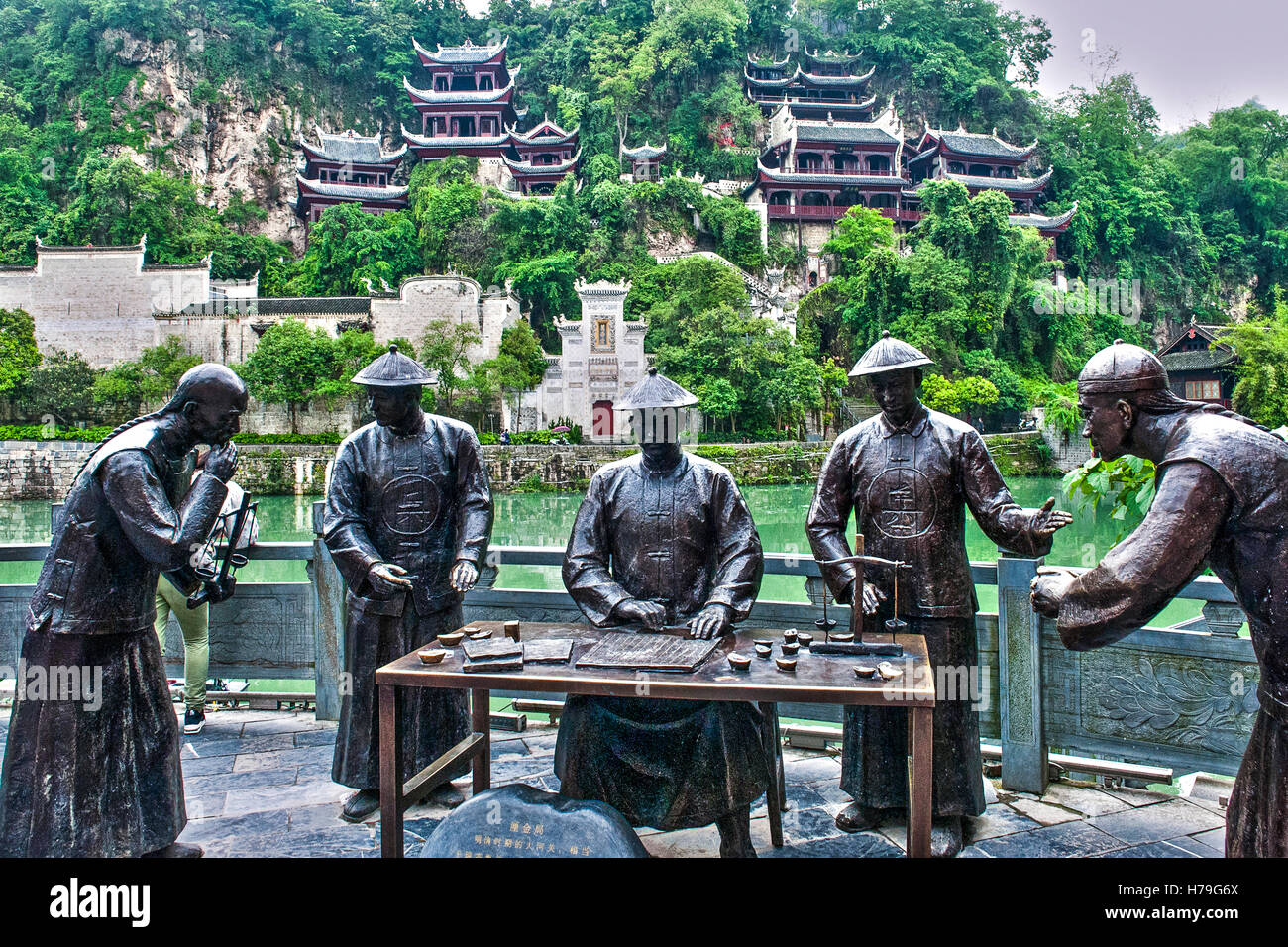Bronze Skulpturen auf einer Seite des Guyang-Flusses in Zhenyuan, Guizhou Provinz, China. Von der anderen Seite die Tempel Komplex "Black Drachenhöhle" Stockfoto