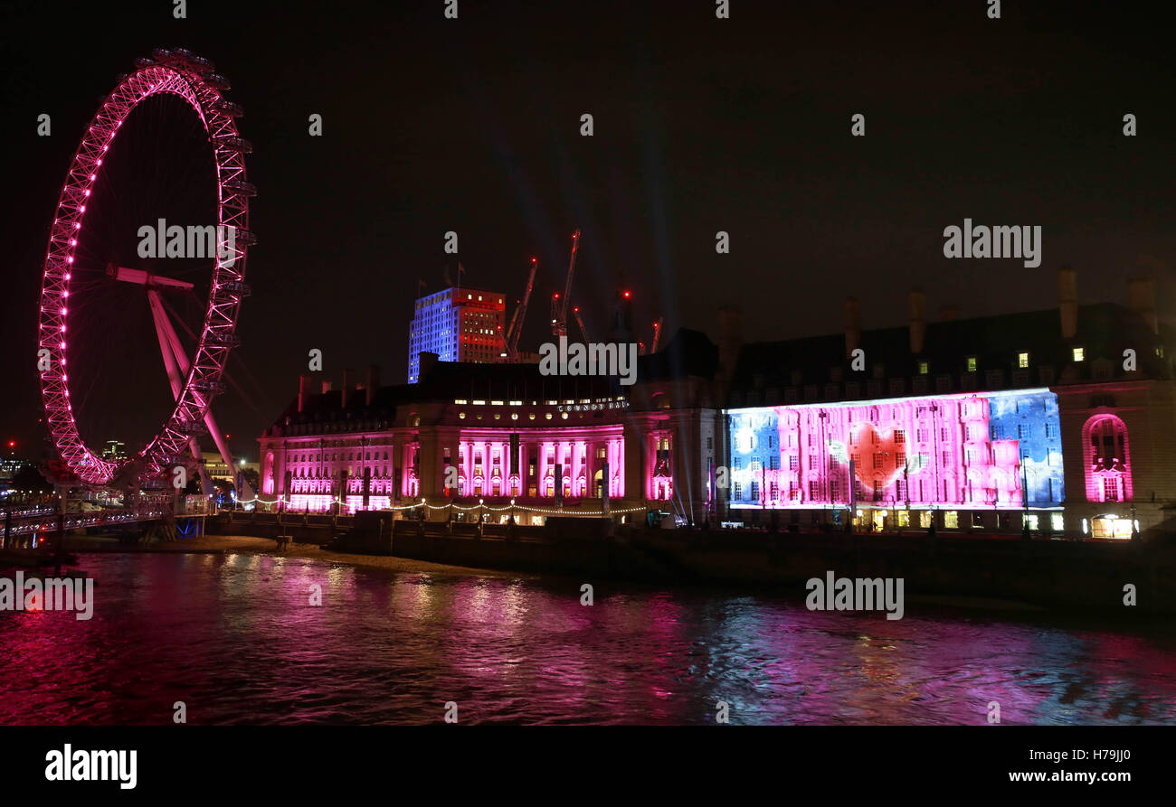 NUR zur redaktionellen Nutzung A Projektion auf London County Hall zeigt Online-Händler Very.co.uk Weihnachten Werbung, wie die hand 100 Geschenk-Geber aus rosa Geschenke an Passanten auf Westminster Bridge in London. Stockfoto