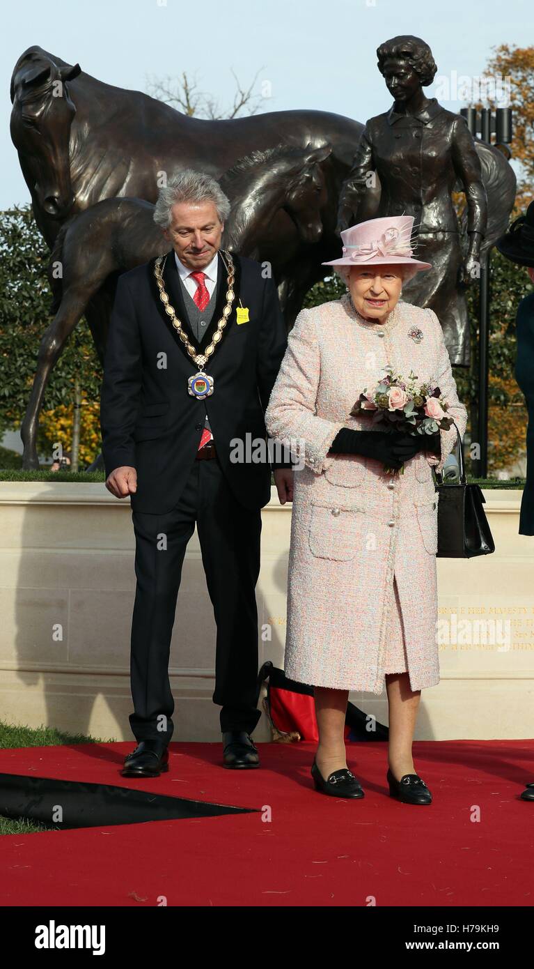 Königin Elizabeth II. mit dem Bürgermeister von Newmarket Andy Drummond Newmarket Racecourse, nachdem sie eine Statue von sich selbst mit einem Fohlen und eine Stute als Geschenk im Jahr von ihrem 90. Geburtstag, bei einem Besuch in der Stadt oft als Sitz des British racing enthüllt. Stockfoto