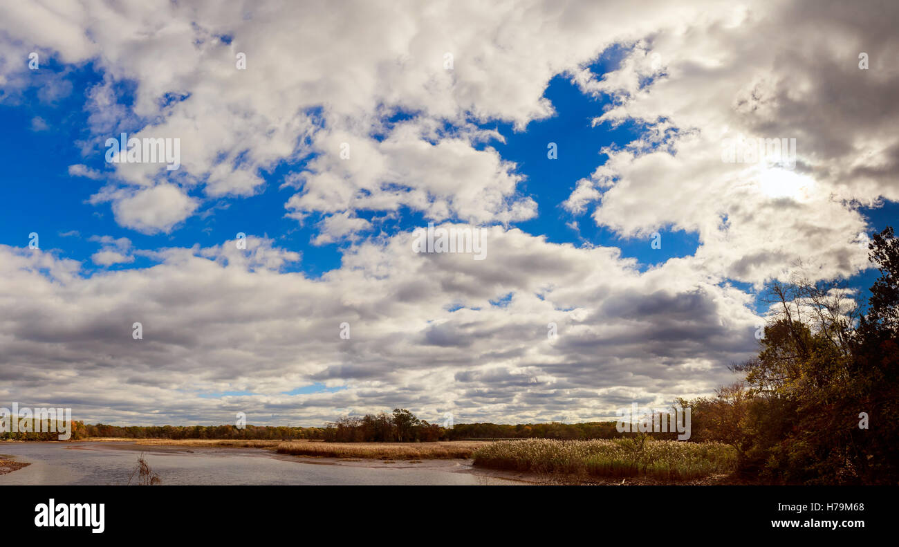 herbstliche Landschaft Fluss und Bäume ohne Blätter blauer Himmel und Wolken an einem sonnigen Tag Stockfoto