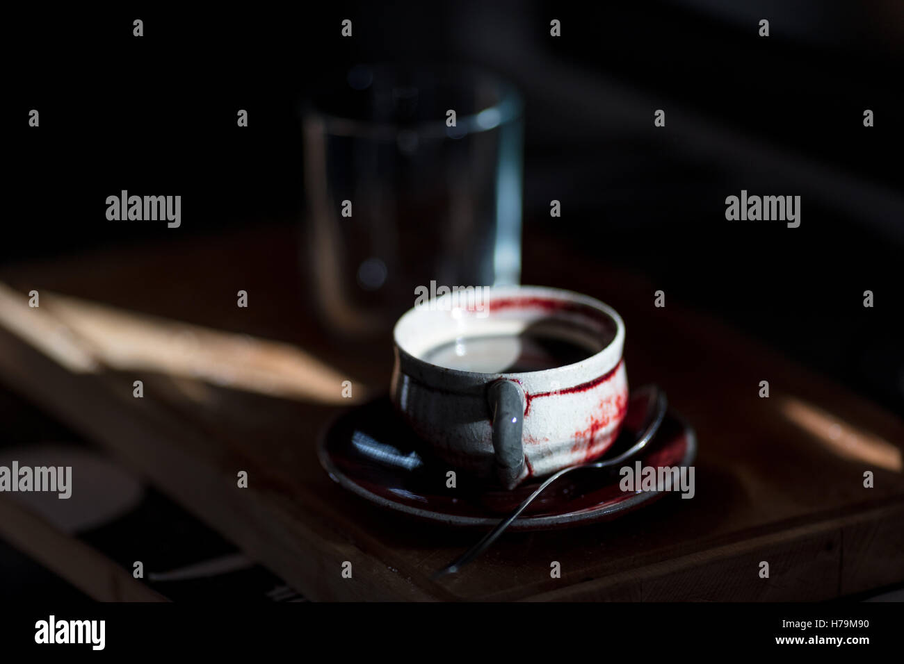 Strahl von Licht, das auf eine Kaffeetasse in der Küche über ein Wooedn Schneidebrett Stockfoto