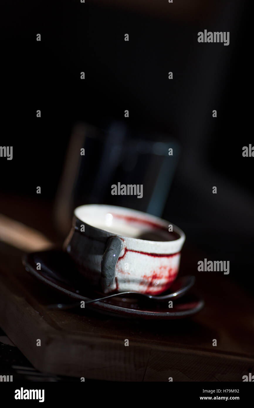 Strahl von Licht, das auf eine Kaffeetasse in der Küche über ein Wooedn Schneidebrett Stockfoto