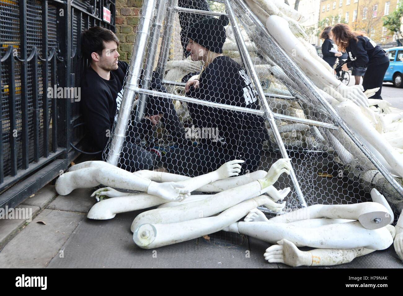 Zwei Demonstranten in einer Struktur, angekettet an den Toren der russischen Botschaft in London, wo 25 Aktivisten aus zwei Kampagnengruppen der Syrien-Kampagne und Syrien Solidarität UK über 800 Gliedmaßen rund um den Eingang in einen Protest gegen die Bombardierung von Zivilisten im Osten Aleppo zerstreut haben. Stockfoto
