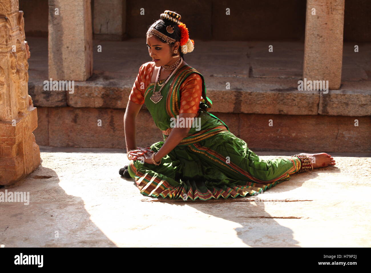 Kuchipudi ist einer der klassischen Tänzerin Formen von Indien, vom Staat Andhra Pradesh. Hier die Tänzerin stellt sich vor einem Tempel mit Skulpturen Stockfoto