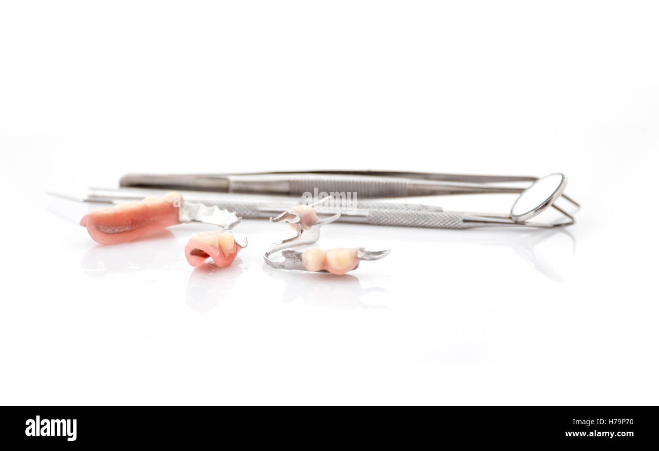 Nahaufnahme von Teilprothesen und Dentalhygienikerin Spiegel auf weißen backgrounda Stockfoto