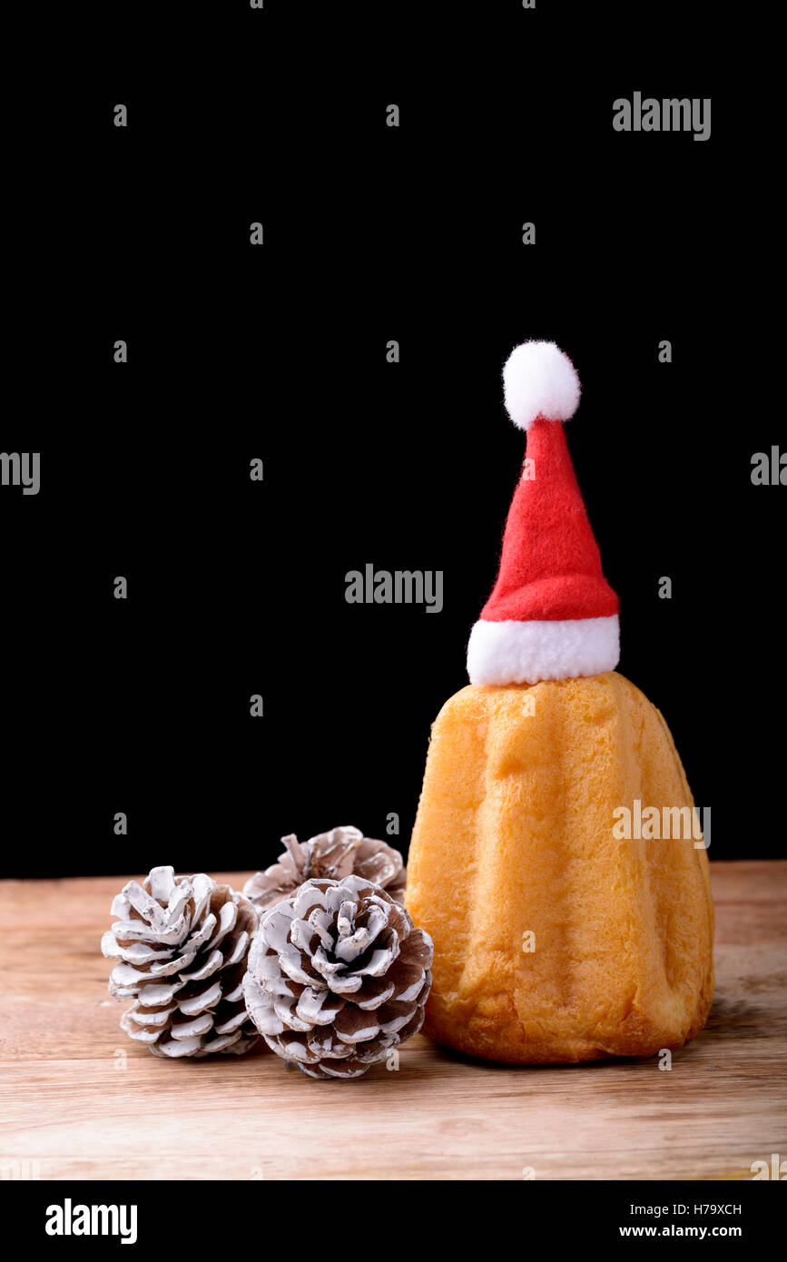Pandoro Kuchen auf Holz mit Tannenzapfen und Hut von Santa Claus Stockfoto