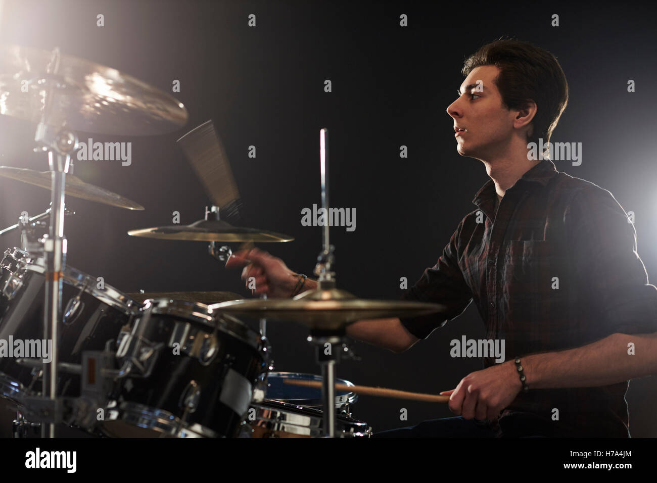 Seitenansicht des jungen Schlagzeuger spielen Schlagzeug im Studio Stockfoto
