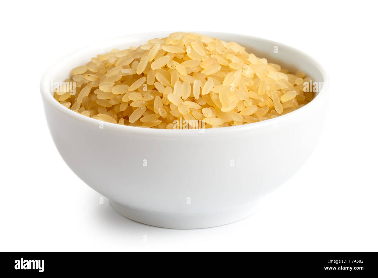 Schüssel mit kurzen Korn parboiled Reis isoliert auf weiss. Stockfoto