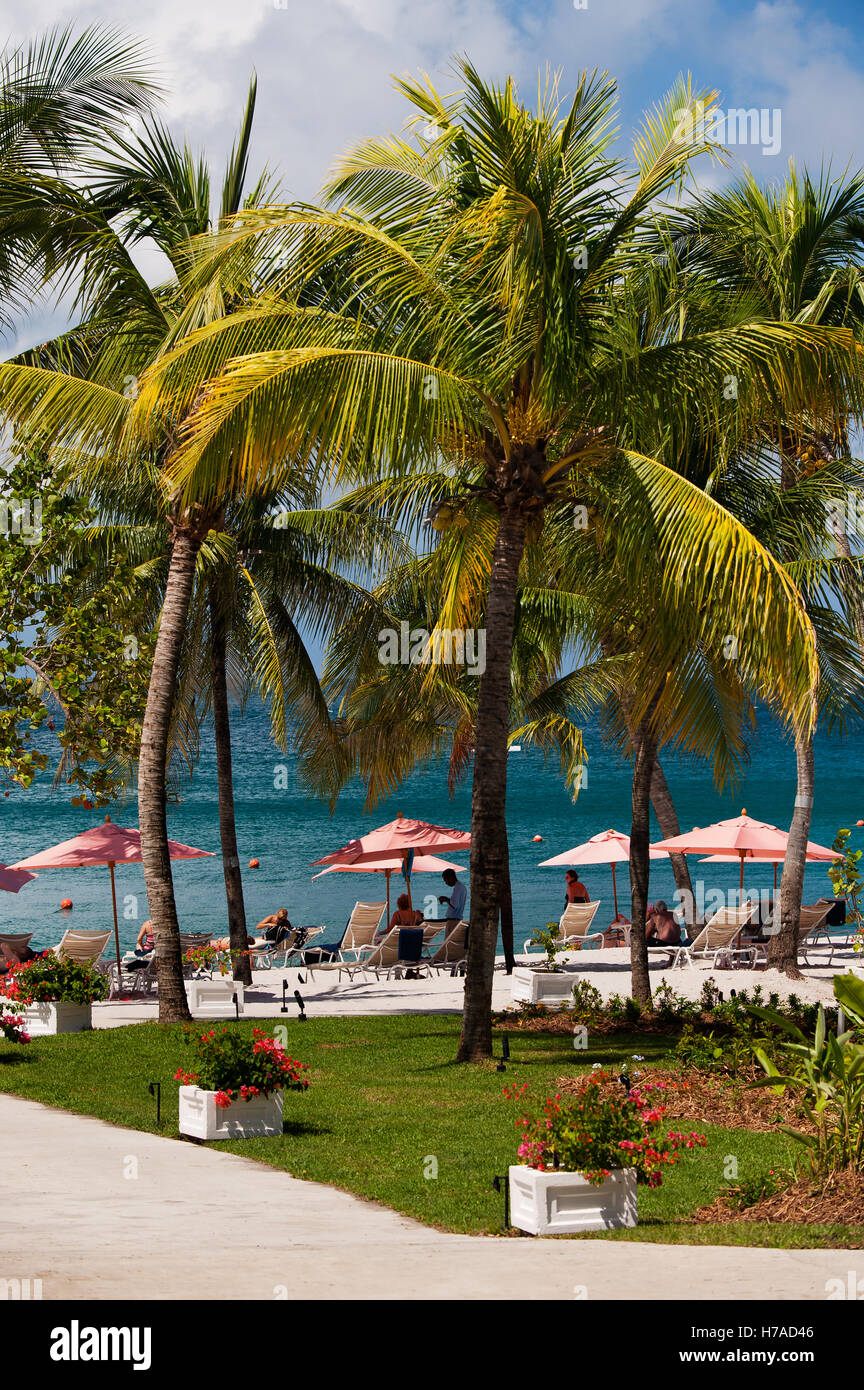 Menschen entspannen Sie sich unter verblasste Sonnenschirme im einsamen Strandresort auf karibischen Insel St. Lucia Stockfoto