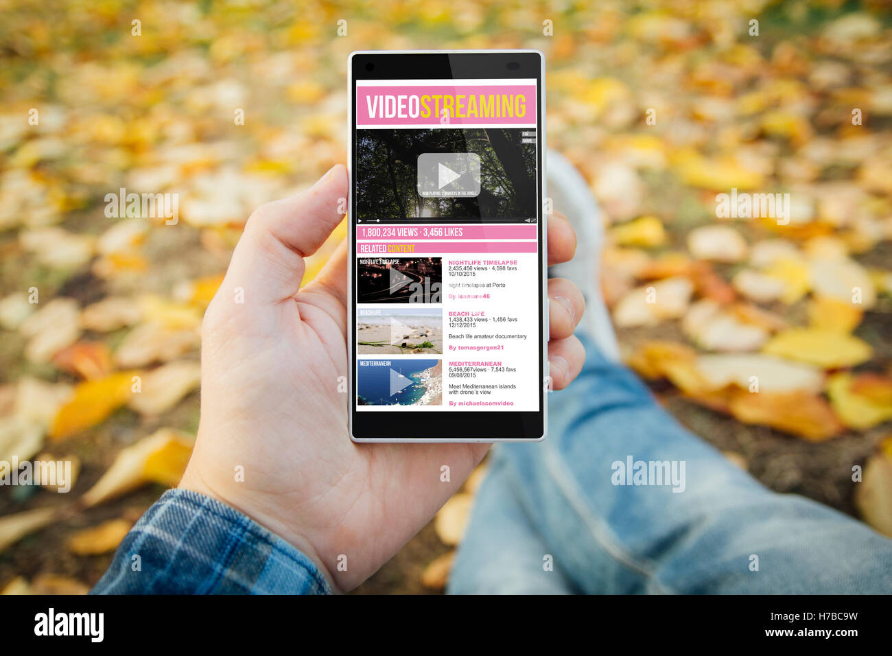 Mann im Park mit Video-Streaming-Smartphone. Alle Bildschirm-Grafiken bestehen. Stockfoto