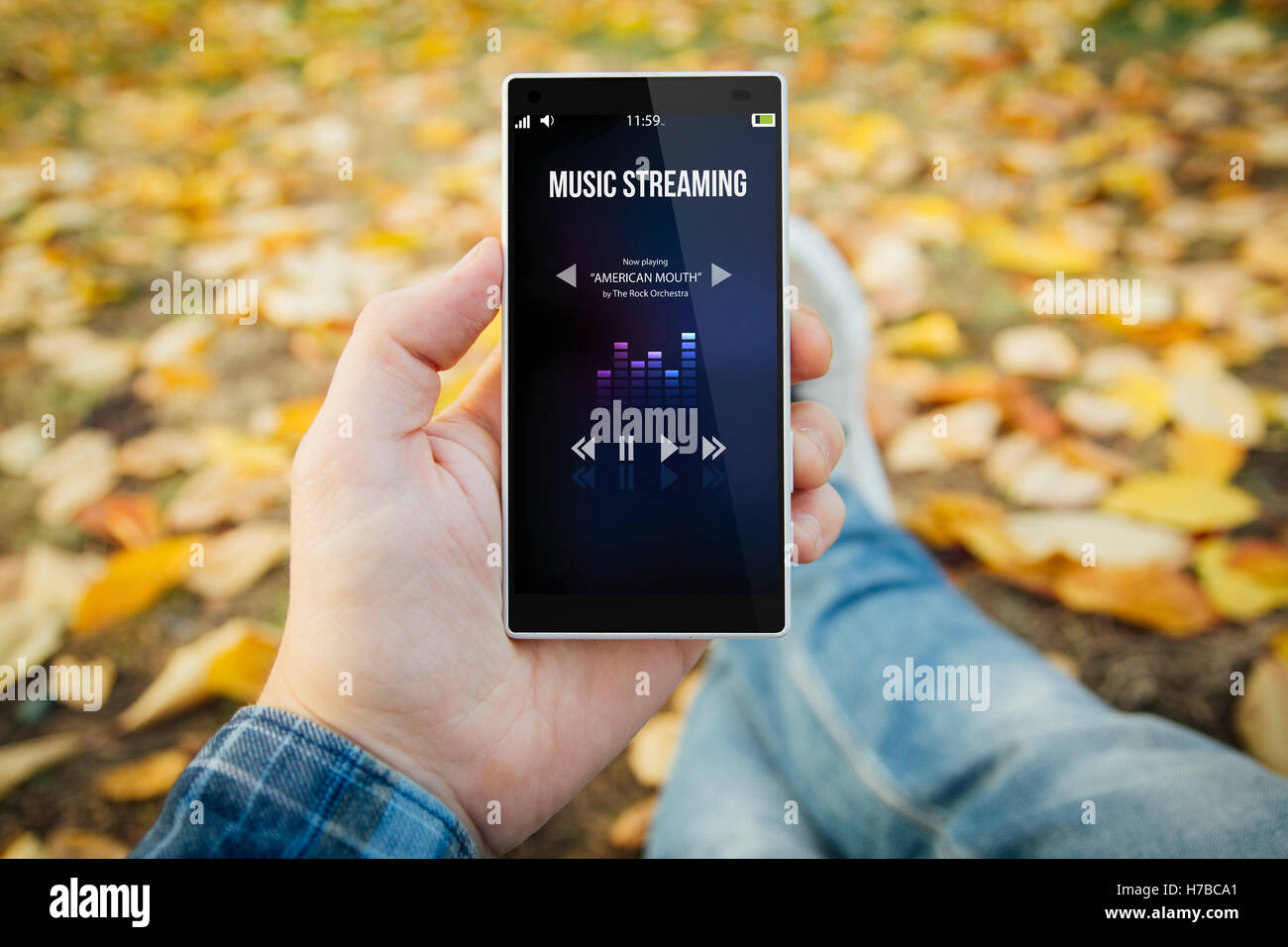 Mann im Park mit Musik-Streaming-Smartphone. Alle Bildschirm-Grafiken bestehen. Stockfoto