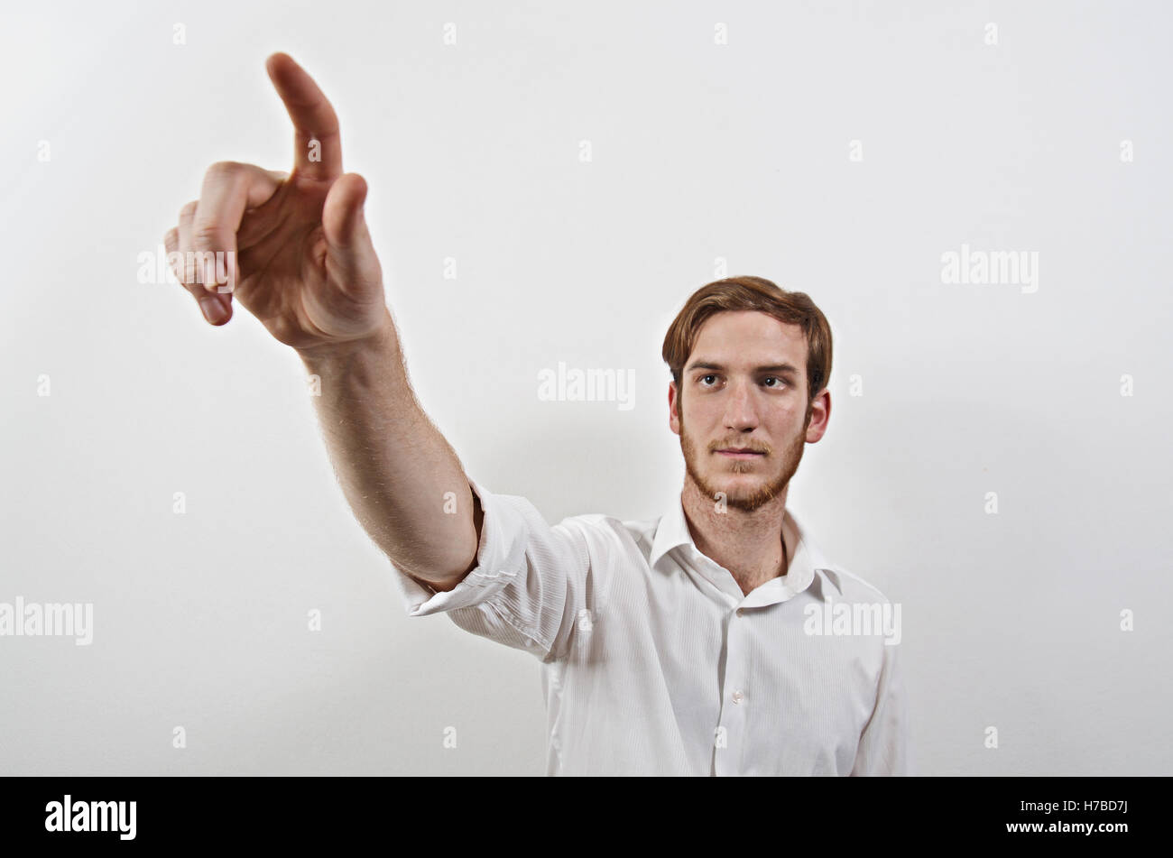 Junge Männchen im weißen Hemd zeigt mit dem Finger Stockfoto