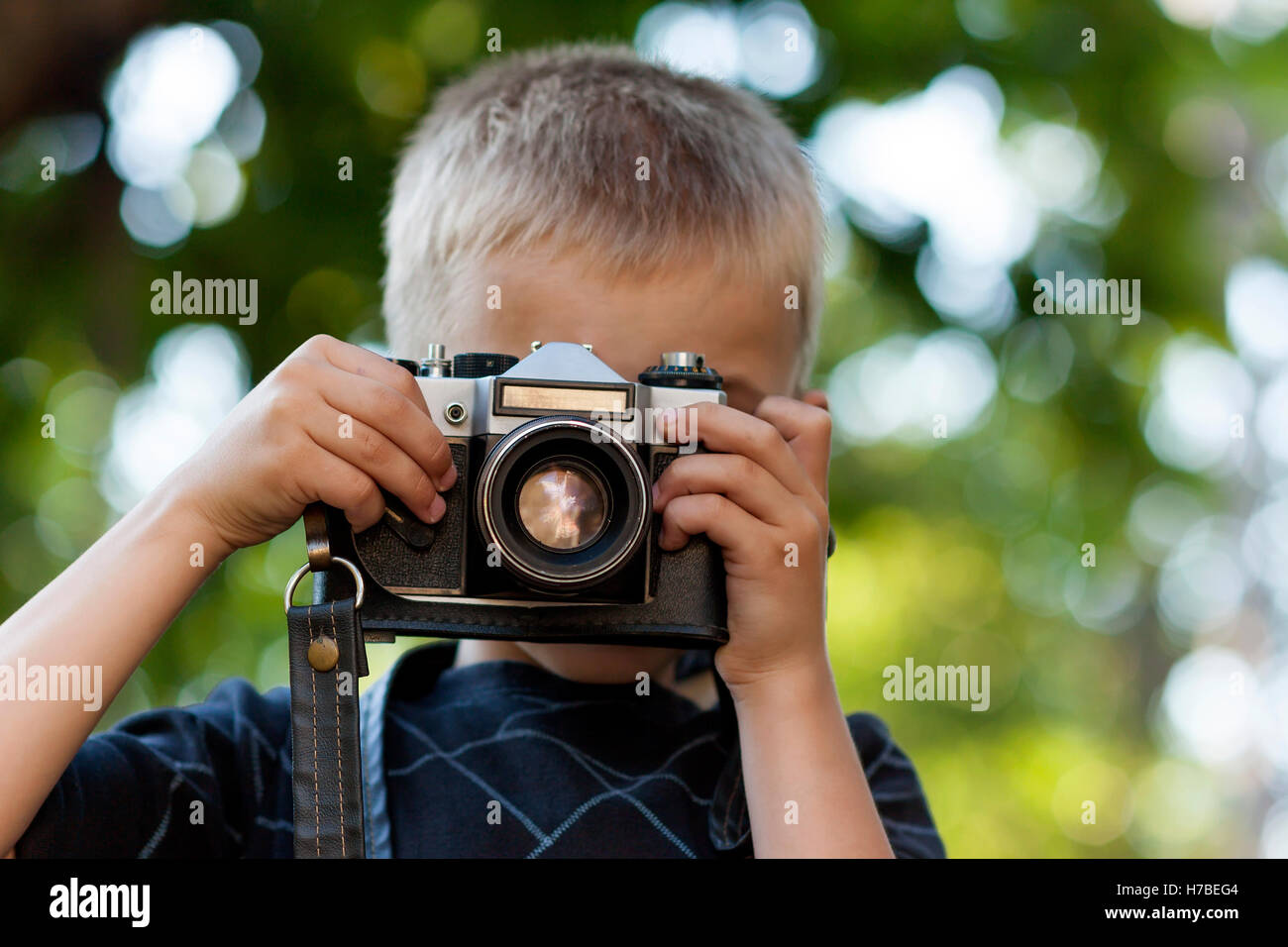 Niedliche kleine fröhlicher Junge mit Vintage Foto-Kamera im freien Stockfoto