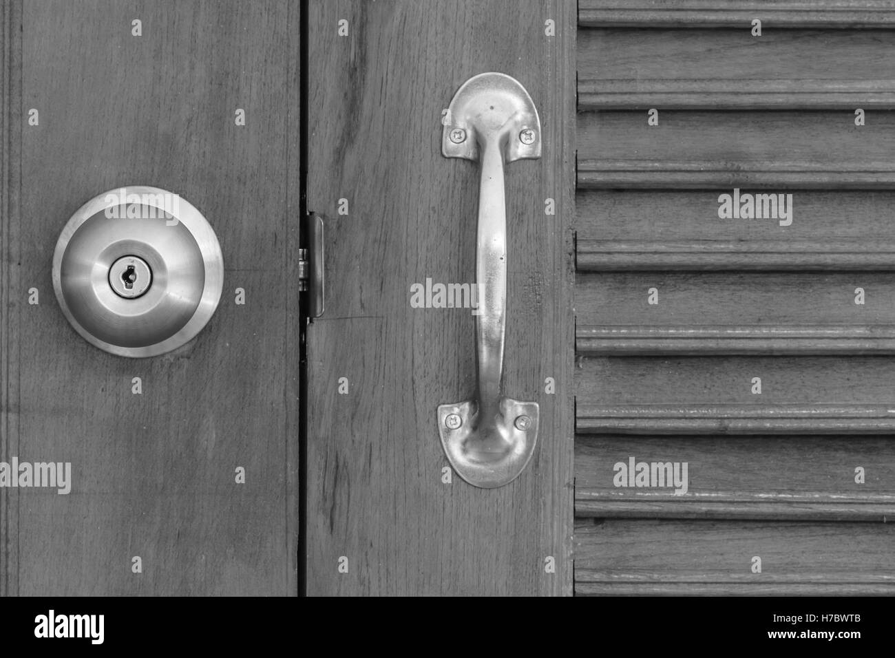 Nahaufnahme von Türklinke mit Holztür, schwarz / weiß-Ton Stockfoto