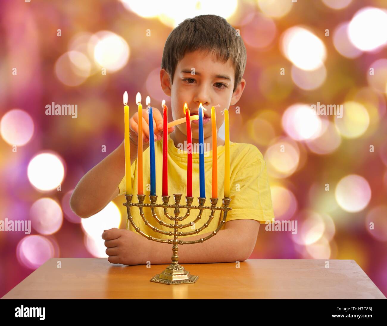 Eine israelische 8 Jahre altes Kind Beleuchtung Hanukkah Menorah Stockfoto