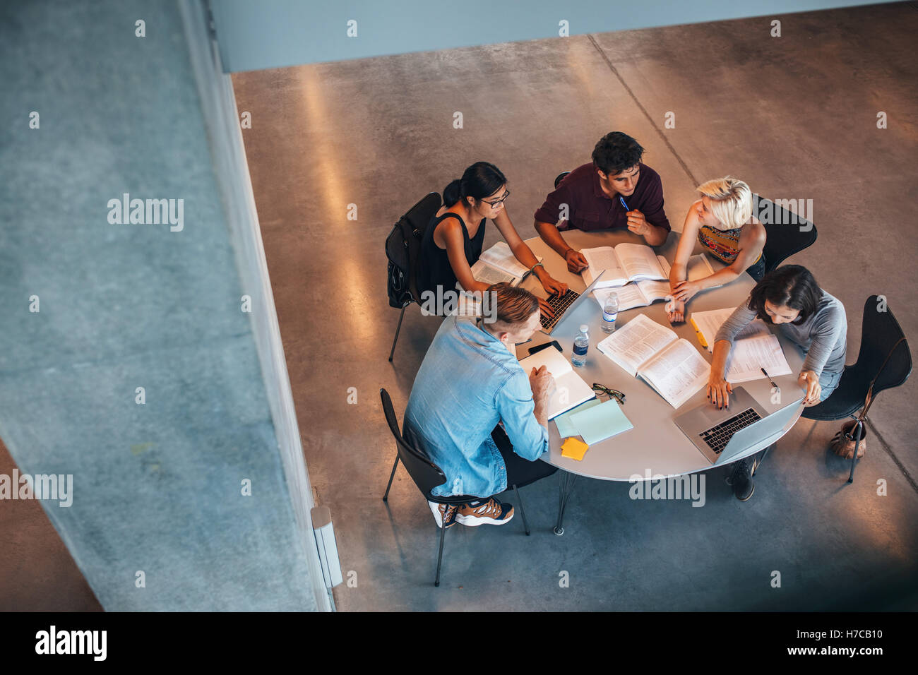 Multiethnische Gruppe von jungen Leuten, die gemeinsam an einem Tisch zu studieren. Junge Studenten in Zusammenarbeit mit ihrer Schule-Zuordnung. Stockfoto