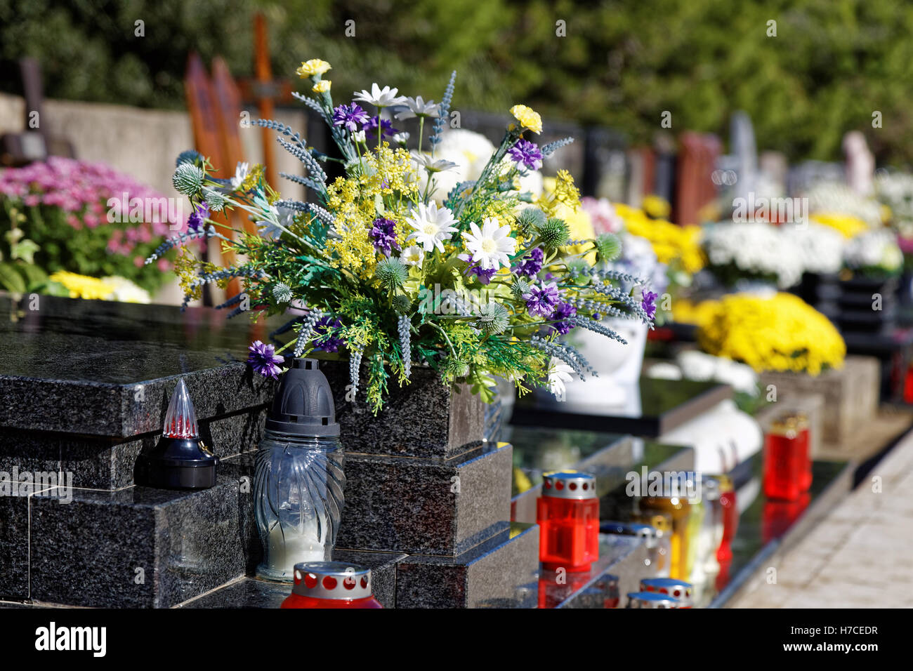 Bouquet von Blumen und Kerzen am Friedhof Stockfoto