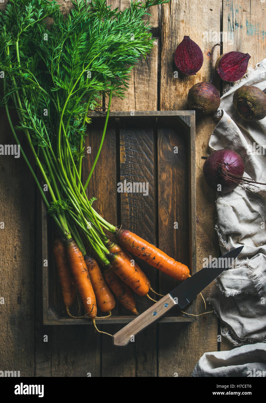 Gesundes Essen kochen Hintergrund. Pflanzliche Inhaltsstoffe. Garten frische Karotten und rote Beete in Holztablett über rustikale Holz bac Stockfoto