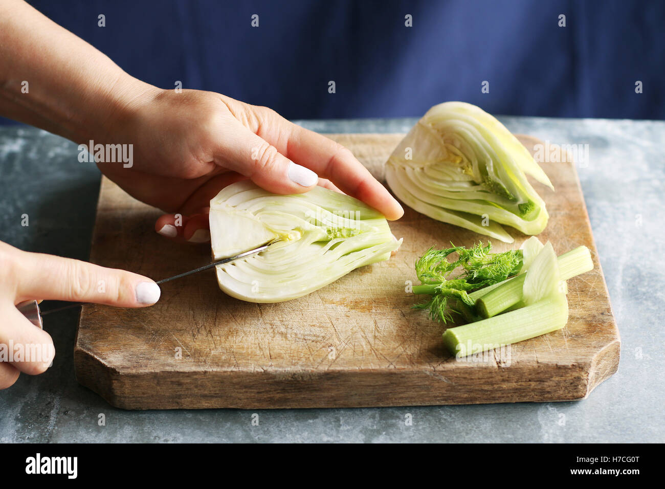 Weibliche Hände mit einem Messer den harten Kern aus einem Fenchel-Zwiebel entfernen. Stockfoto