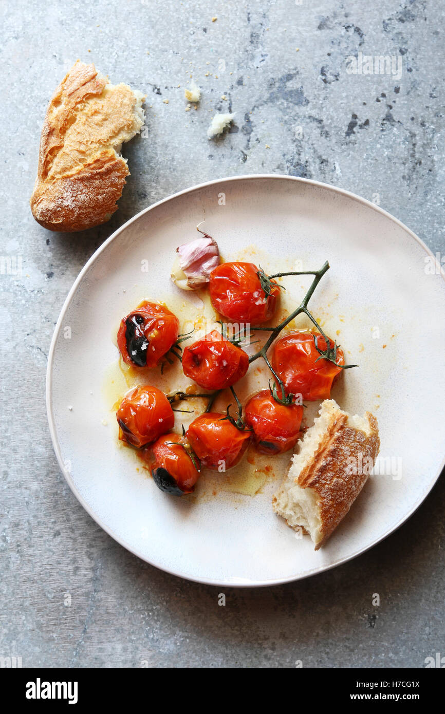 Gerösteten Cherry Tomaten mit Olivenöl und Meersalz auf einem weißen Teller. Ansicht von oben Stockfoto