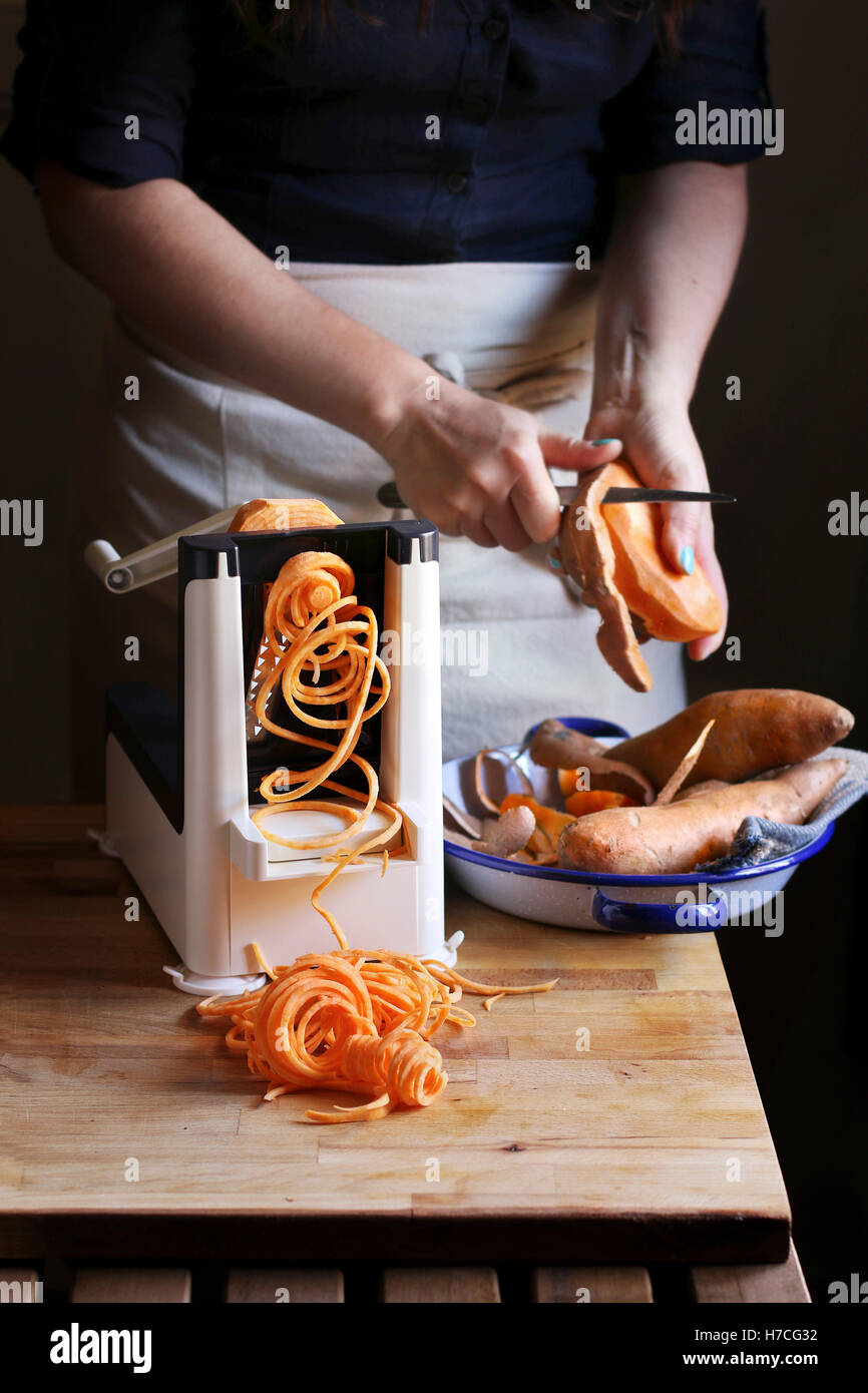 Süßkartoffel-Nudel machen mit einer Spiralizer Maschine Stockfoto