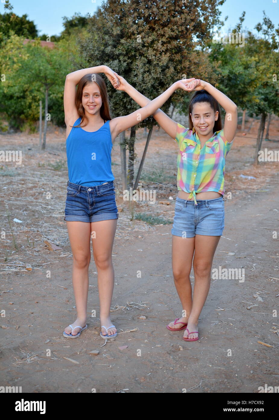 Beste Freunde für immer - zwei 12-jährige Mädchen Hand in Hand in eine Unendlichkeit ewig Zeichen zu bedeuten BFF Stockfoto