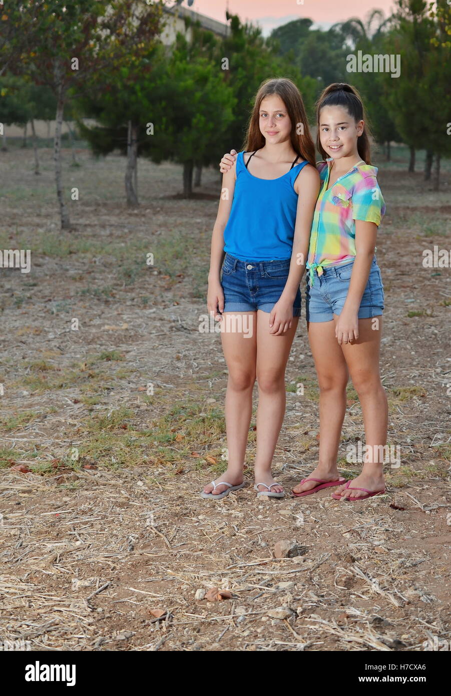 Beste Freunde für immer - zwei 12-jährige Mädchen im Teenageralter umarmt bei Sonnenuntergang Stockfoto