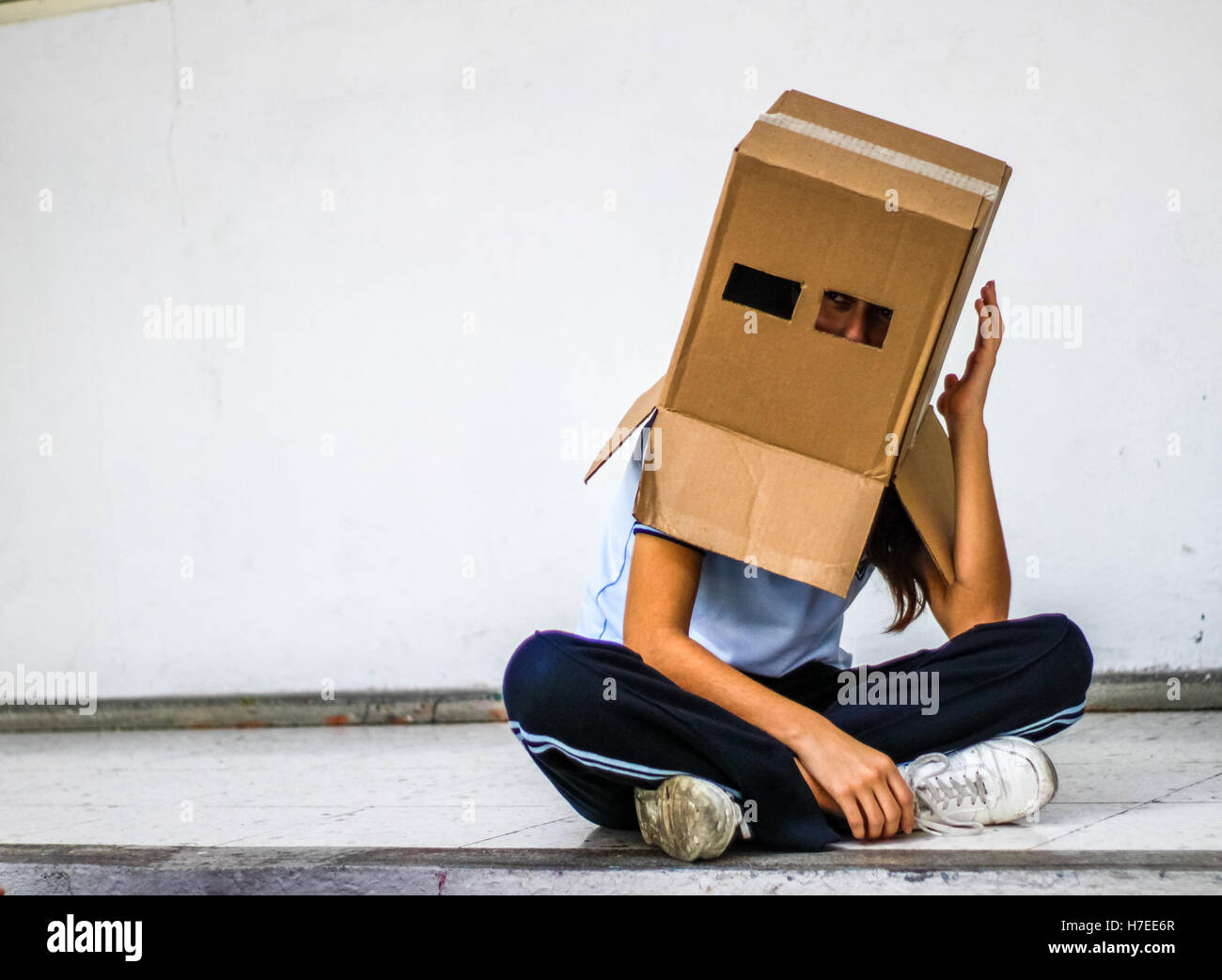 Foto eines Teen mit einem Karton Kopfmaske Stockfoto