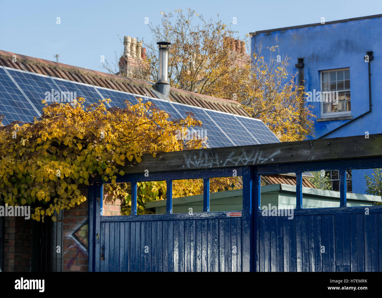 Blau gemalte Haus und Tor mit Herbstfärbung. Stockfoto