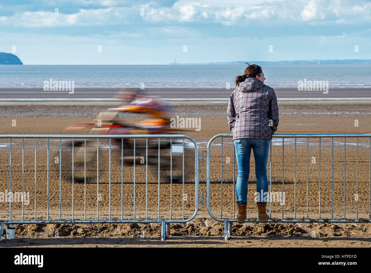 Ein einsamer Zuschauer blickt auf als ein Motorradfahrer Rennen von Weston Strand Rennen, Somerset UK. Stockfoto