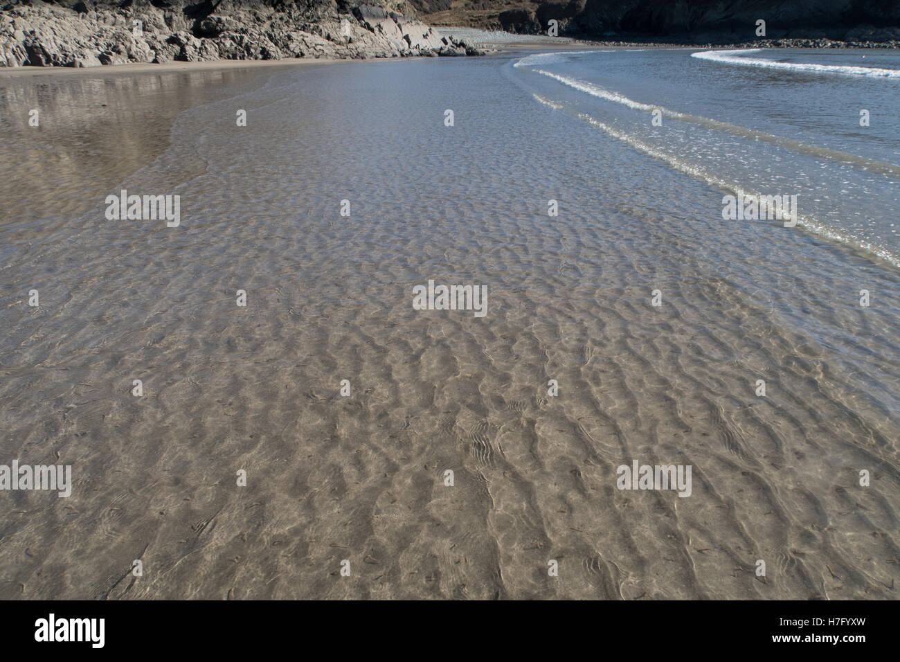 Auf der Suche durch sauberes Wasser, wellige Asnd an einem Strand in Großbritannien Stockfoto