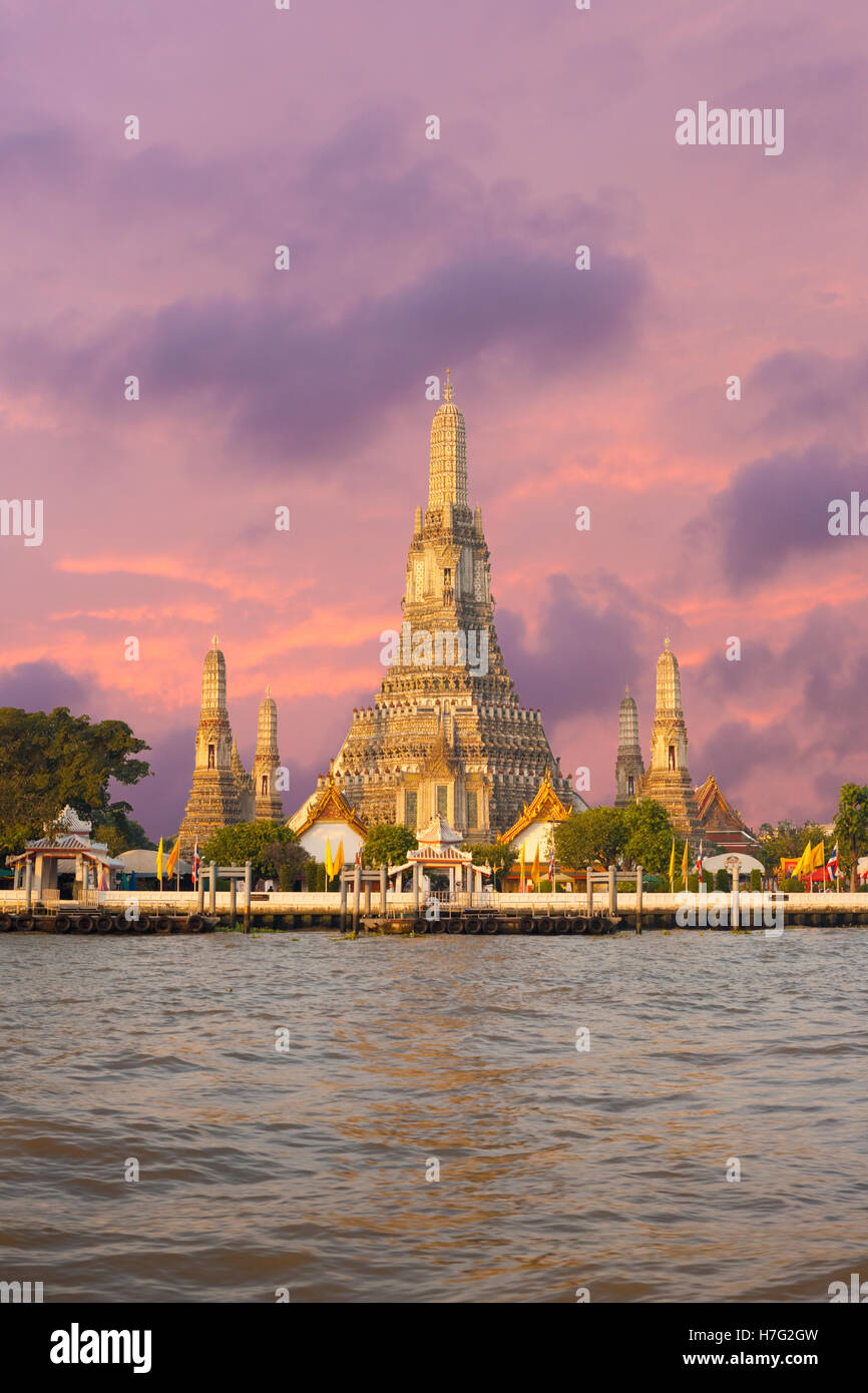 Wat Arun, der Tempel der Morgenröte, liegt entlang des Chao Phraya Flusses bei Sonnenaufgang am Morgen mit einem feurigen roten Himmel in Bangkok, Thailand Stockfoto