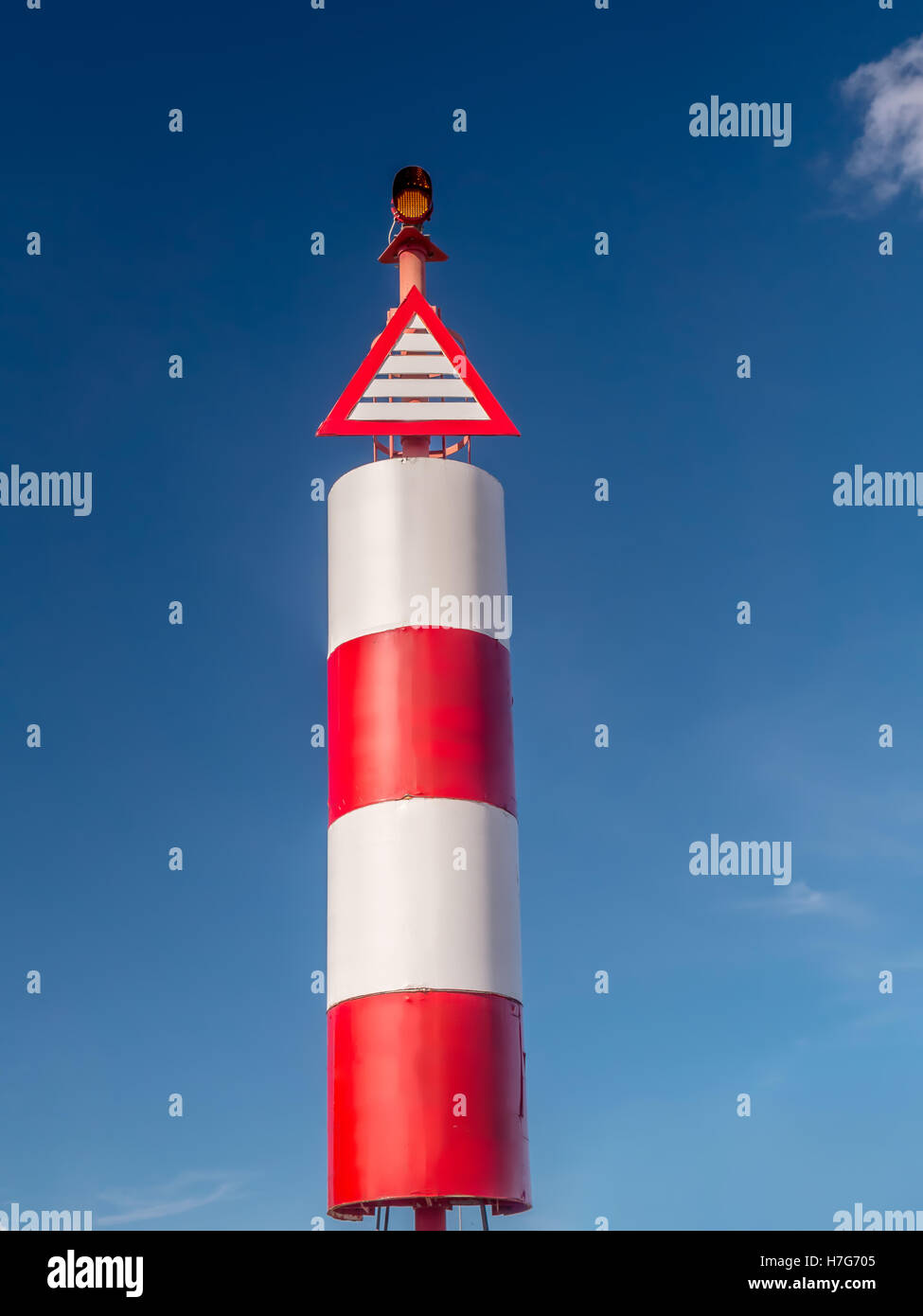 Rot-weiße Leuchtturm am Hafen gegen den Himmel geschossen Stockfoto