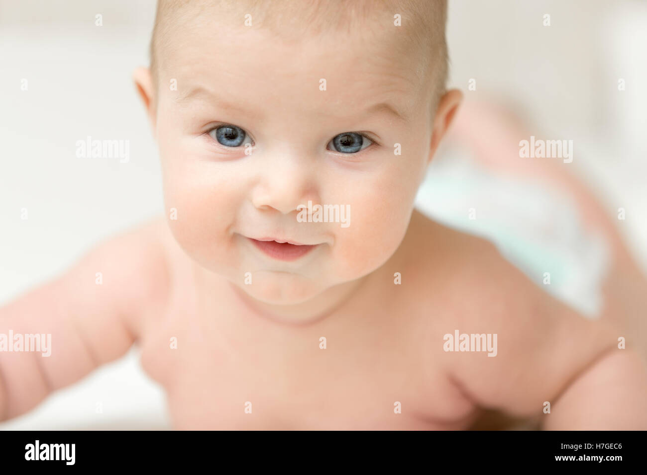 Porträt eines entzückenden lächelnden Babys hält Kopf Stockfoto