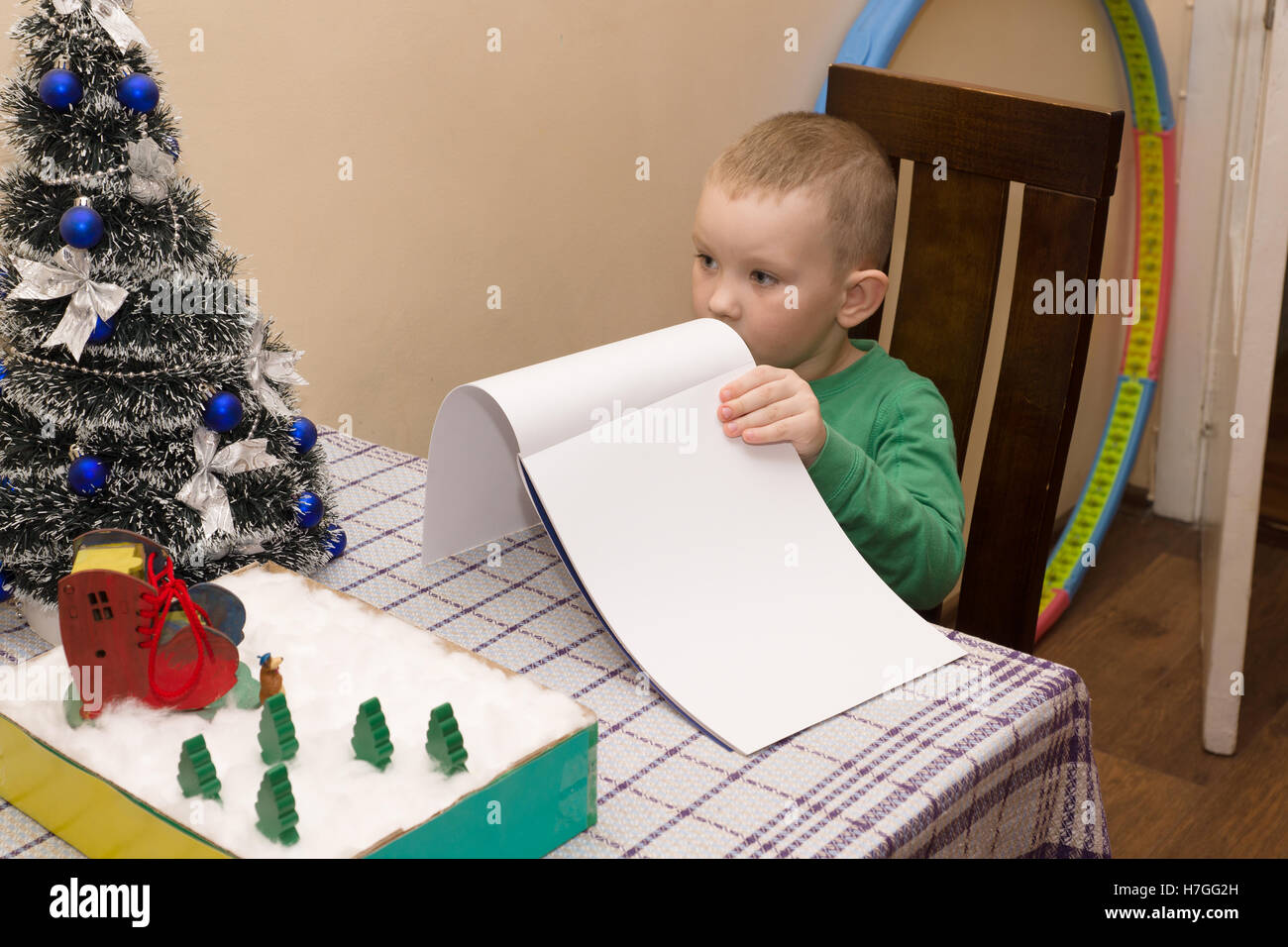Junge schreibt einen Brief an den Weihnachtsmann brachte ihm Geschenke Stockfoto