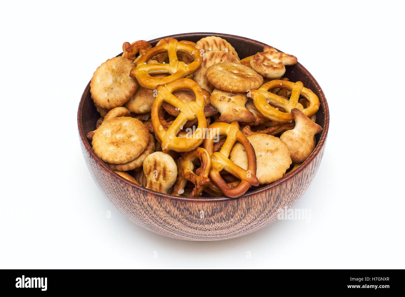 Mischung aus salzigen Snacks (Kekse und Brezeln) in Holzschale isoliert auf weißem Hintergrund Stockfoto