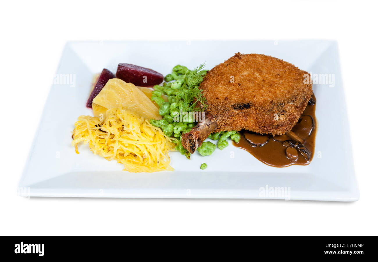 Geröstete Honig glasierte Schweinekotelett mit Gemüse, süße Kartoffelchips und Marsala Portobello Pilzsauce. Stockfoto