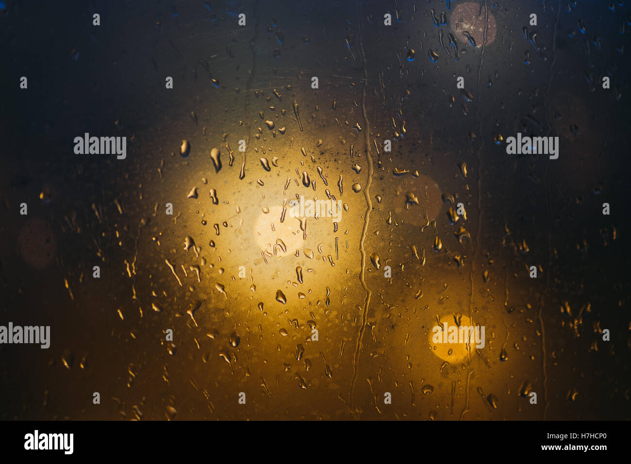 Unscharfe Lichter durch dampfenden Fenster mit dunklem Hintergrund, Regentropfen, selektiven Fokus Stockfoto