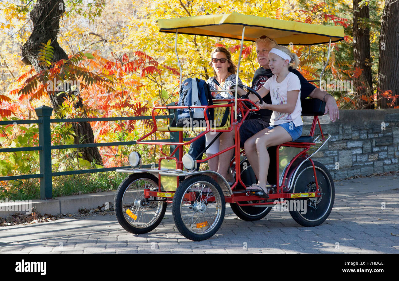 Junges Mädchen ihre Familie auf einem doppelten Surrey Fahrrad im Minnehaha Park hausieren. Minneapolis Minnesota MN USA Stockfoto