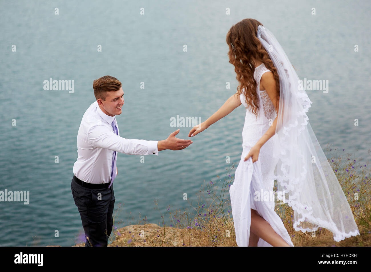 Braut und Bräutigam zu Fuß in der Nähe von schönen See. Hochzeitspaar in der Liebe Stockfoto