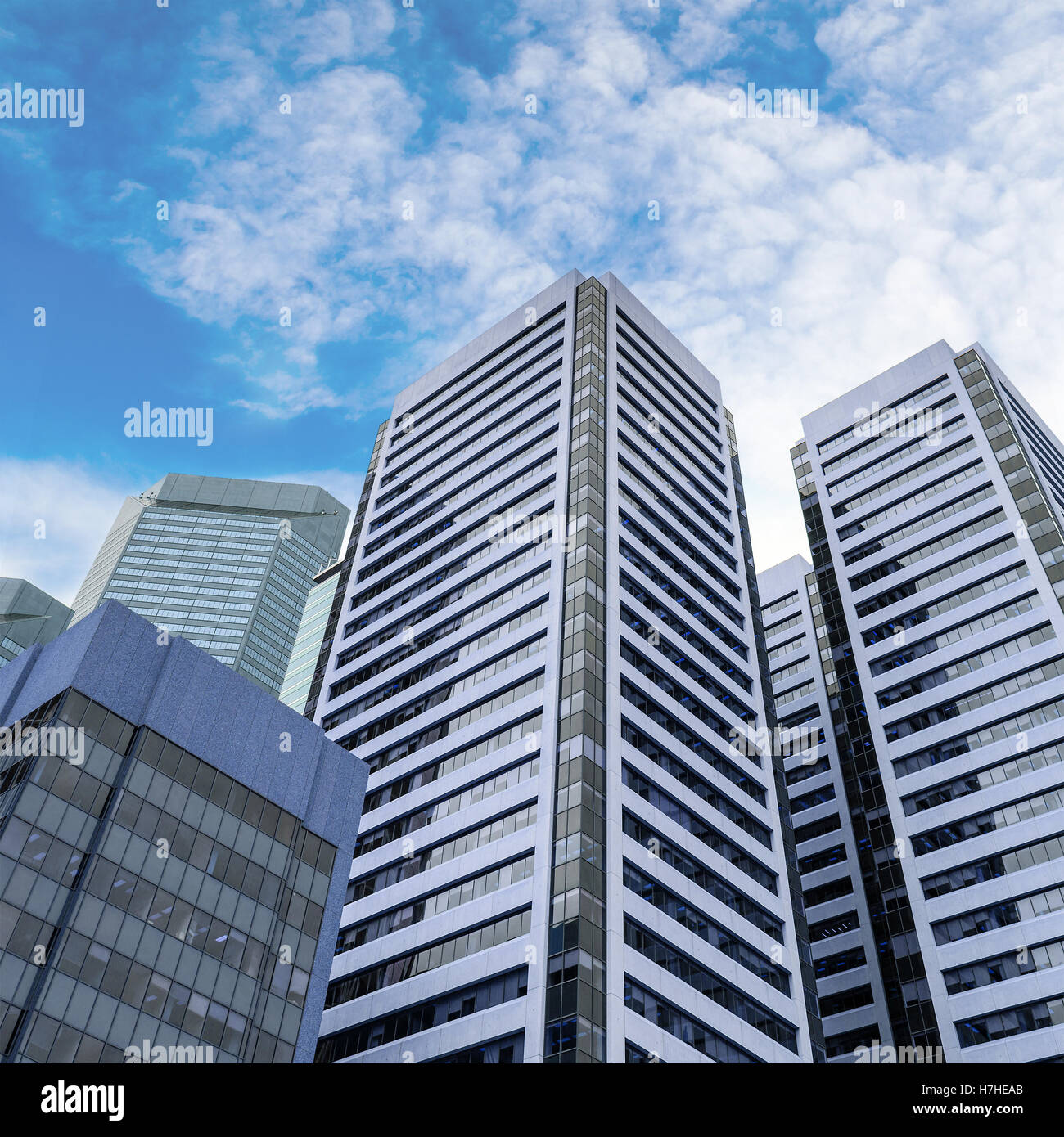 Prost Blick auf moderne Wolkenkratzer in downtown Geschäftsviertel vor einem blauen und bewölkten Himmel. Stockfoto