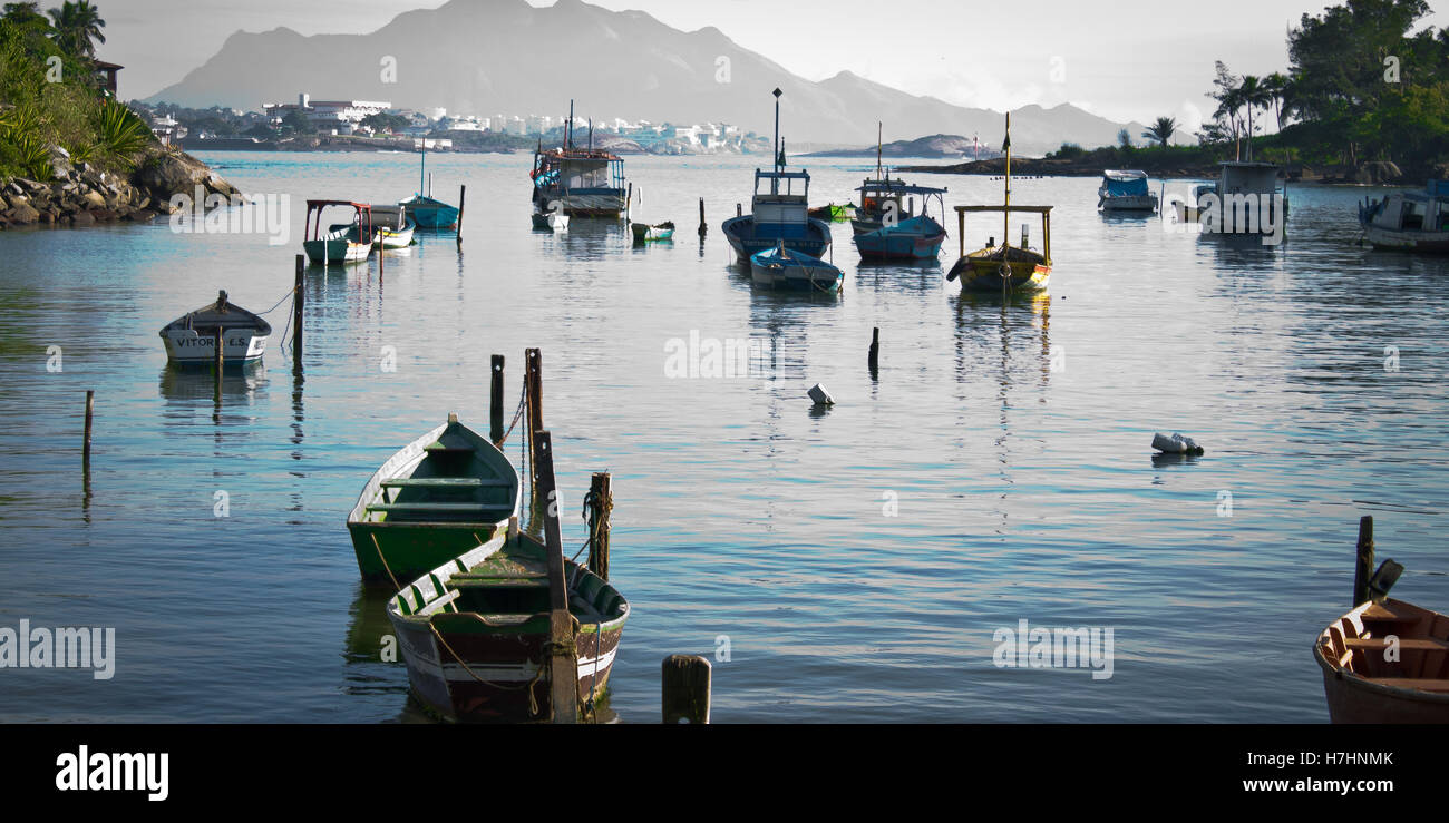 Blick auf die Fischerboote im ruhigen Hafen-Stadt und die Berge im Hintergrund Stockfoto