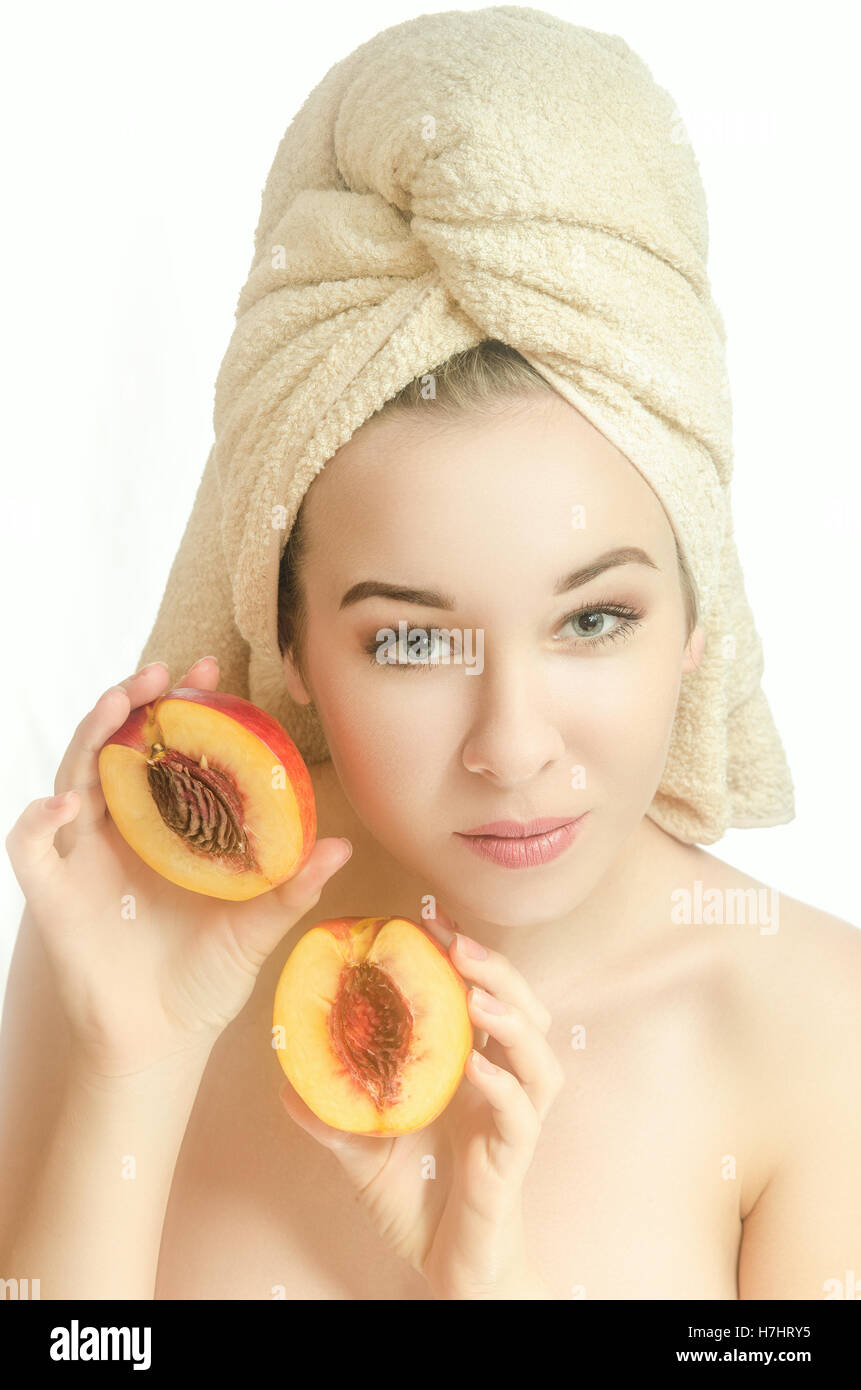 Das Mädchen mit dem Handtuch auf den Kopf und ein Pfirsich Stockfoto
