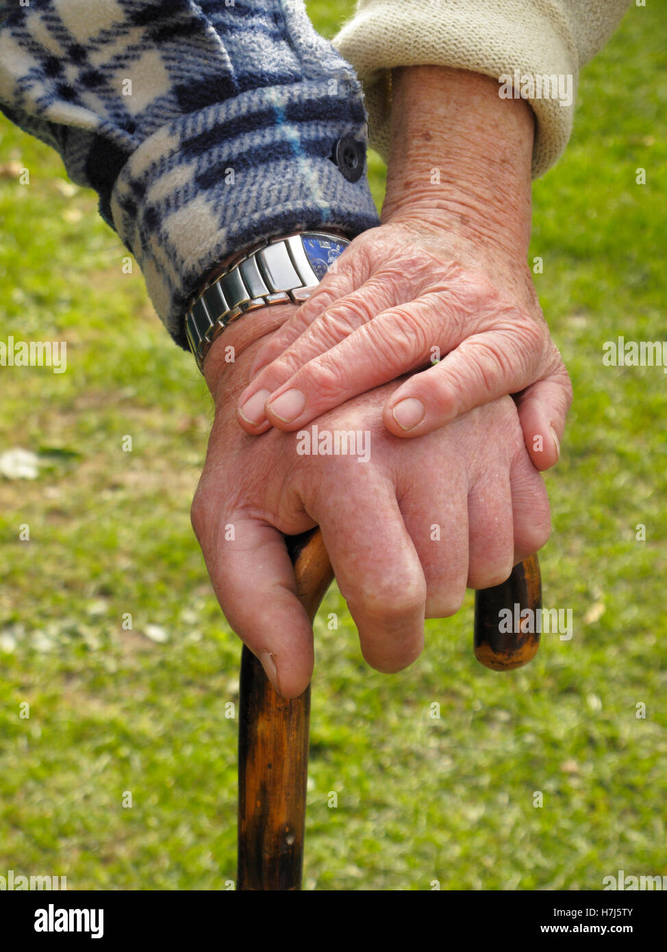 Hände von einem älteren paar auf einen Spazierstock Stockfoto