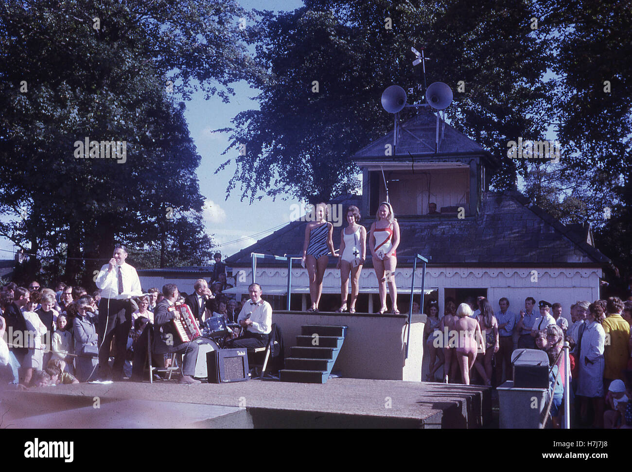 England, 1960er Jahre, weibliche Kandidaten in Badebekleidung die Teilnahme an einem Schönheitswettbewerb in einem Holiday Camp, mit einem Ansager und Band auf der Bühne. Erstellt von Billy Butlin preiswerte Ferien für Familien Briitsh arbeiten, zehn Ferienlager zur Verfügung zu stellen wurden zwischen 1936 und 1966 erbaut. Stockfoto