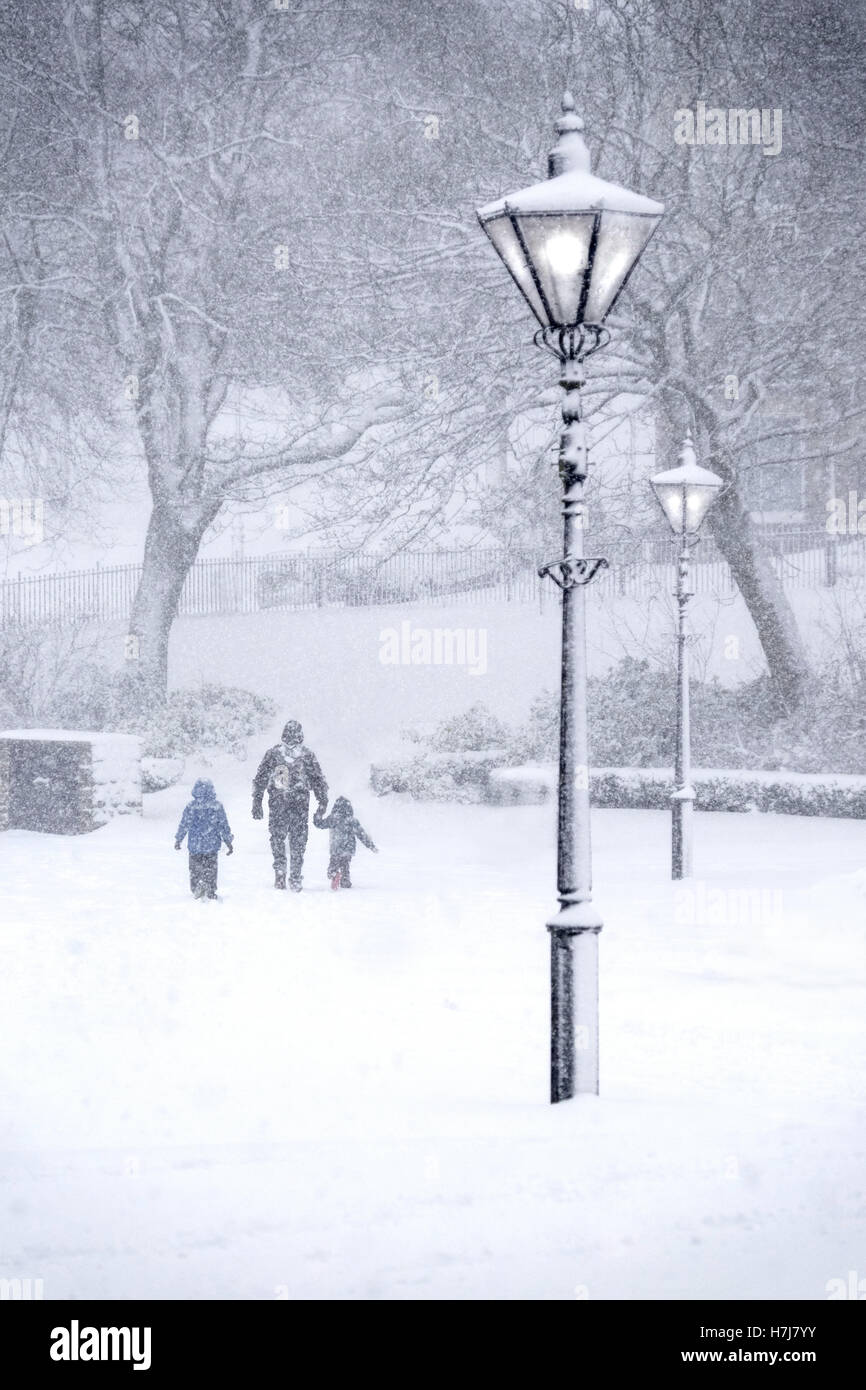 Buxton, Derbyshire in starkem Schneefall. Eltern und Kinder im Garten-Pavillon Stockfoto
