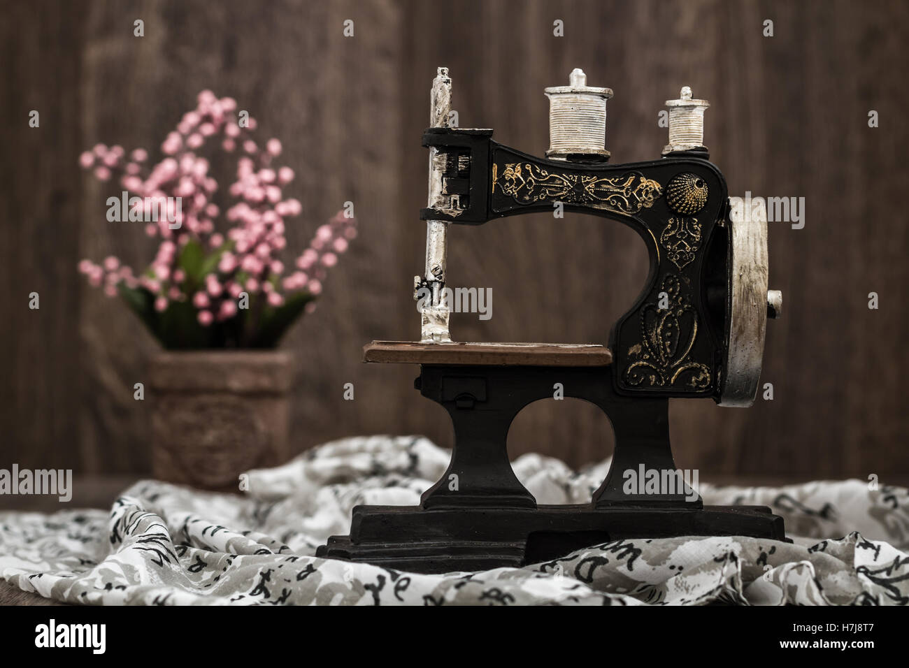 Kleinen nostalgischen dekorative Nähmaschine auf braunem Holz Hintergrund Stockfoto